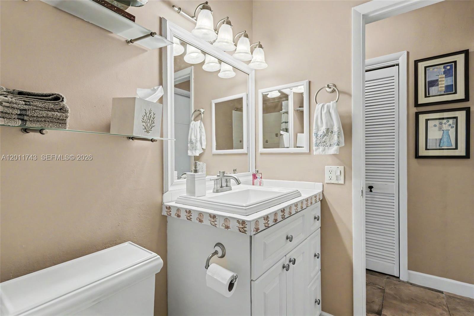 1801 South Surf Road, Unit 2G Hollywood, FL 33019 - Photo 31 of 32 a bathroom with a sink a toilet and a mirror