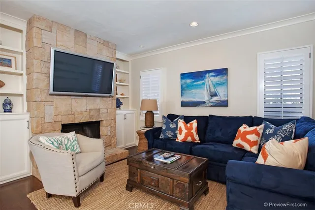 a living room with furniture a flat screen tv and a fireplace