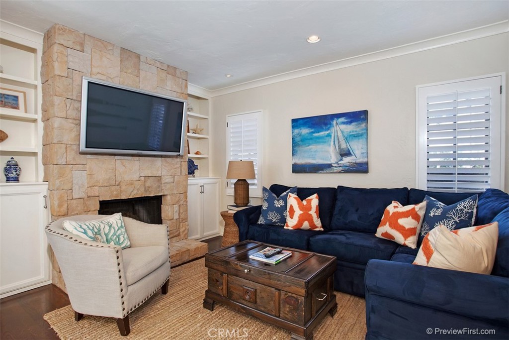 441 Carnation Avenue Corona del Mar, CA 92625 - Photo 6 of 25 a living room with furniture a flat screen tv and a fireplace