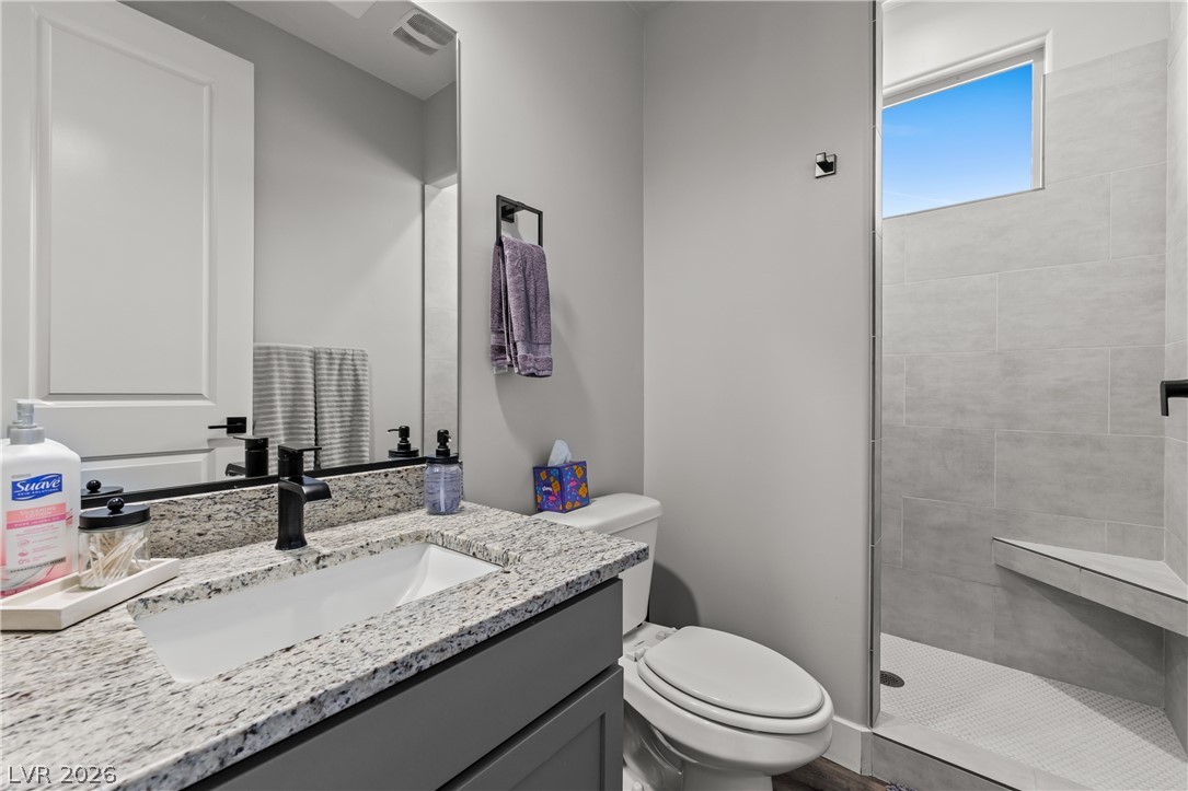 1436 Manassas Ridge Mesquite, NV 89027 - Photo 6 of 77 Modern bath featuring a granite vanity and a spacious, tiled walk-in shower with a window.