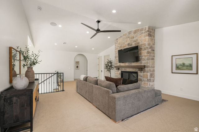 4871 South Homestead Way Washington, UT 84780 - Photo 70 of 151 Living area featuring ceiling fan, a stone fireplace, arched walkways, light colored carpet, and lofted ceiling