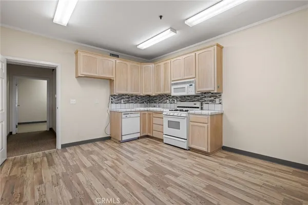 a kitchen with white cabinets and white appliances