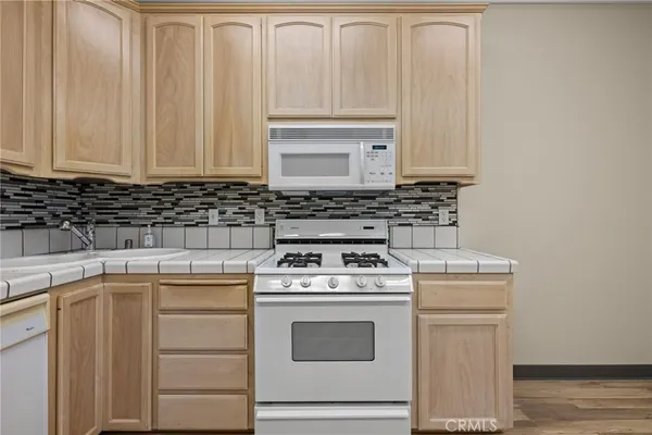 a view of a kitchen with wooden floor and stainless steel appliances