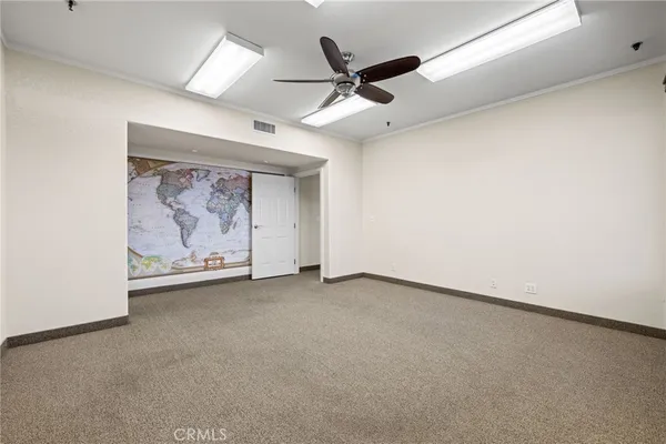 an empty room with a ceiling fan and a window