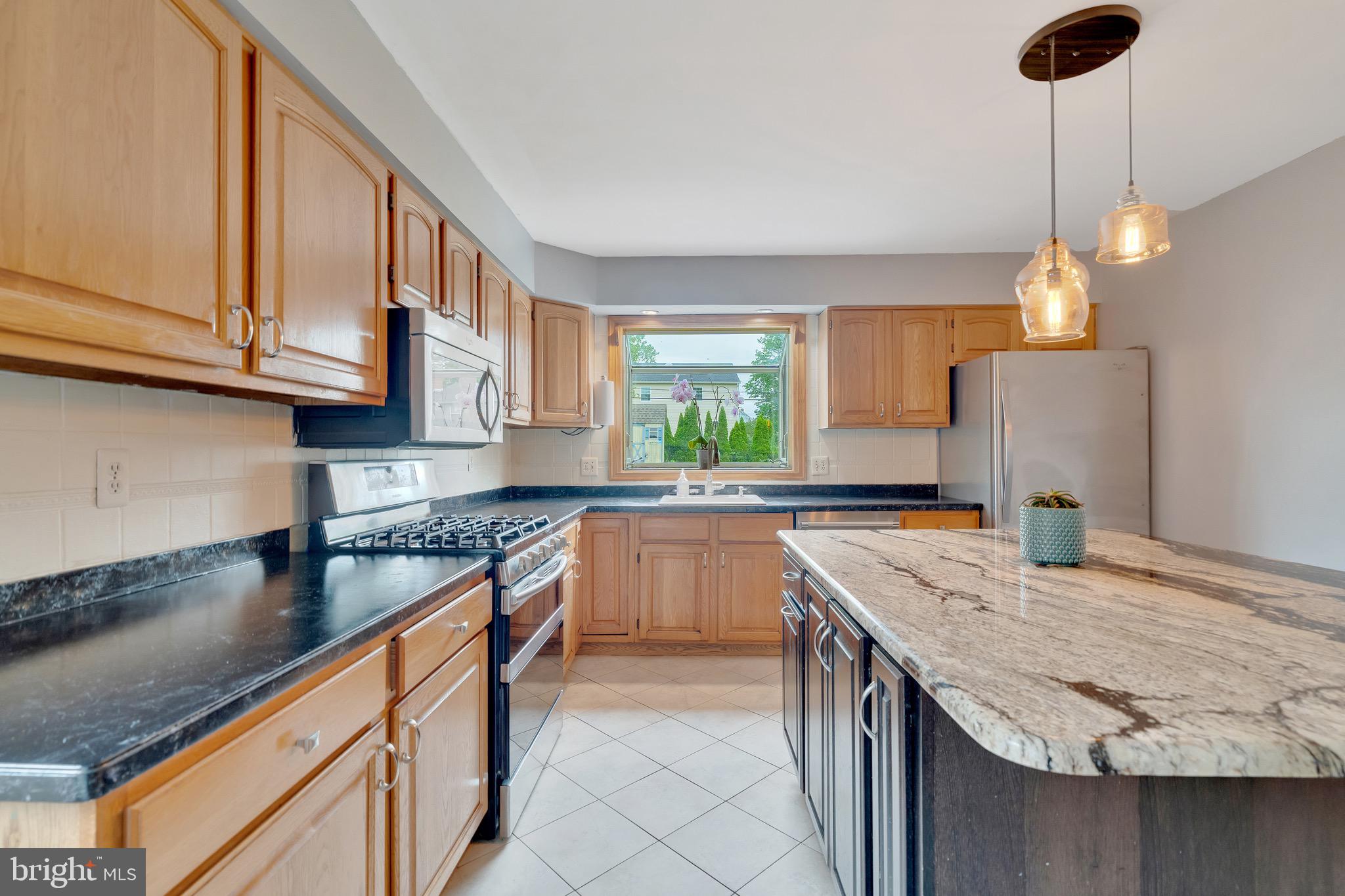2317 Poplar Road, Unit 24 Havertown, PA 19083 - Photo 8 of 42 a kitchen with stainless steel appliances granite countertop a sink a stove and a wooden cabinets