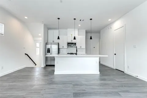 a view of kitchen with stainless steel appliances kitchen island sink and refrigerator