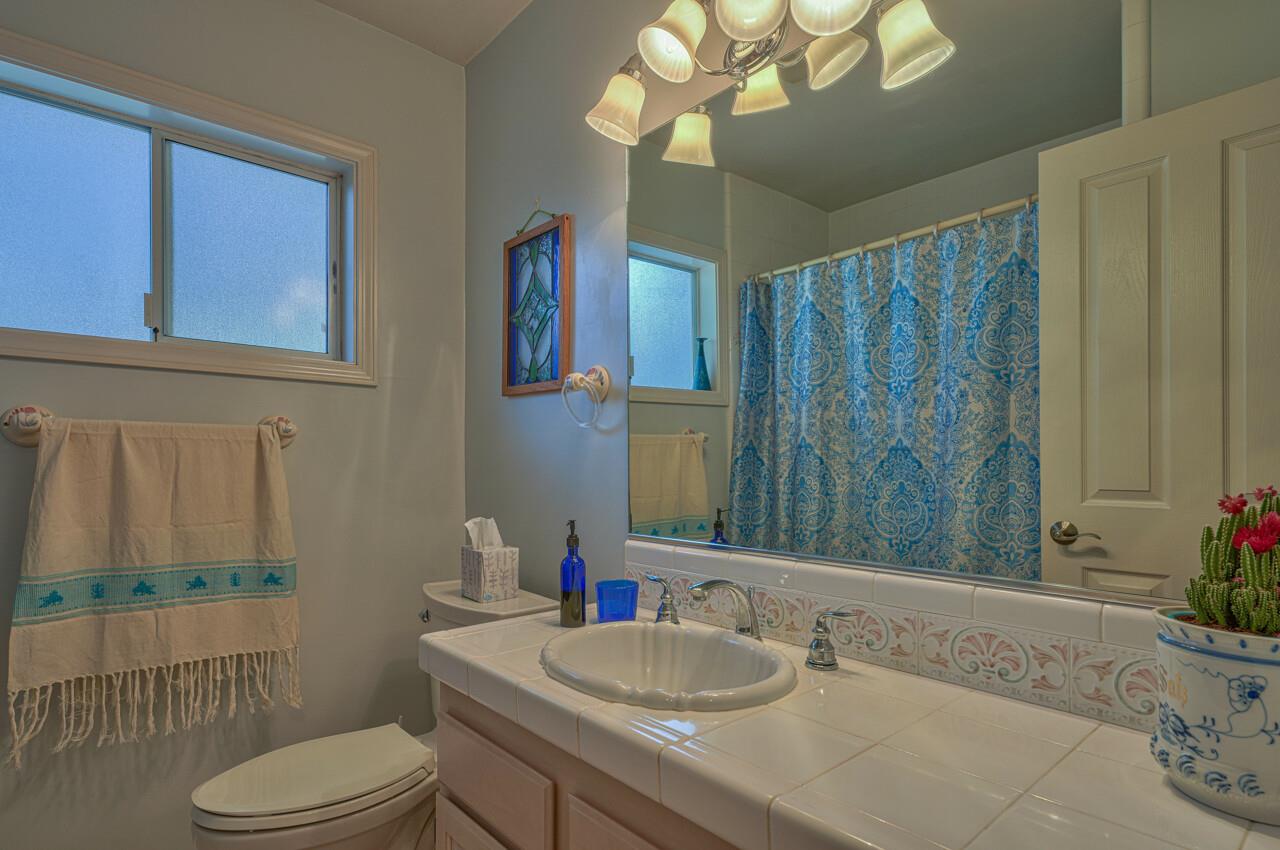26382 Riverside Place Carmel, CA 93923 - Photo 23 of 29 a bathroom with a granite countertop bathtub sink vanity mirror and toilet