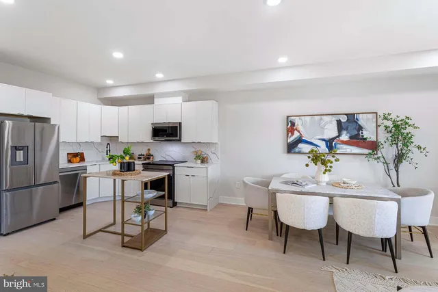 a kitchen with stainless steel appliances a refrigerator a sink and cabinets