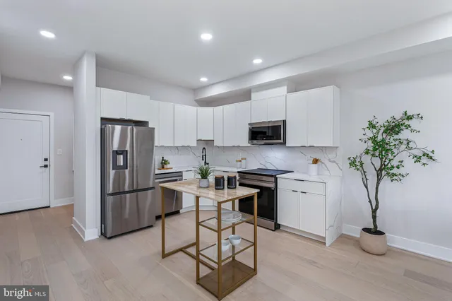 a kitchen with stainless steel appliances granite countertop a refrigerator and a stove top oven