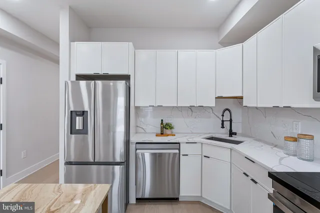 a kitchen with a refrigerator and white cabinets