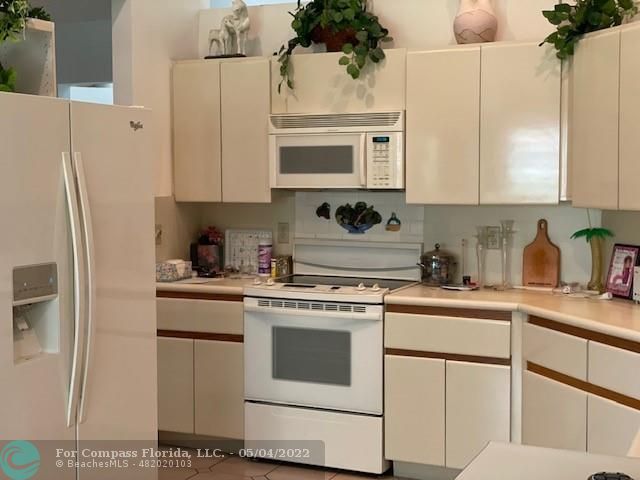 Oaktree Estates Oakland Park, FL 33309 - Photo 6 of 17 a kitchen with cabinets stainless steel appliances and a counter space