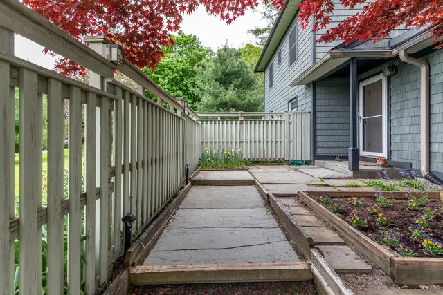 a view of a pathway of a house with wooden fence