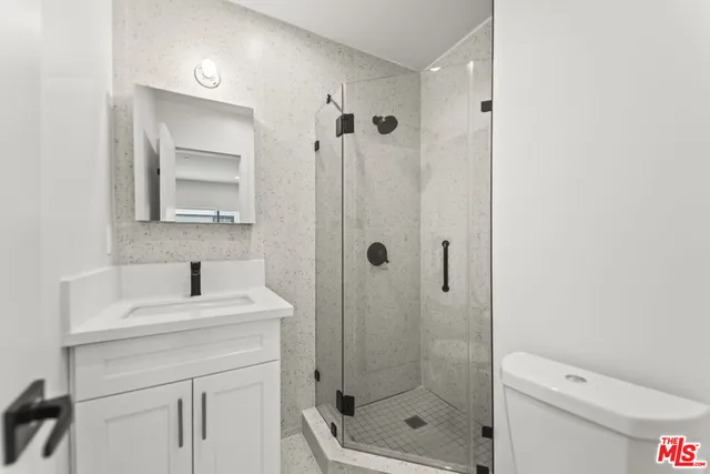a bathroom with a shower a sink and a mirror
