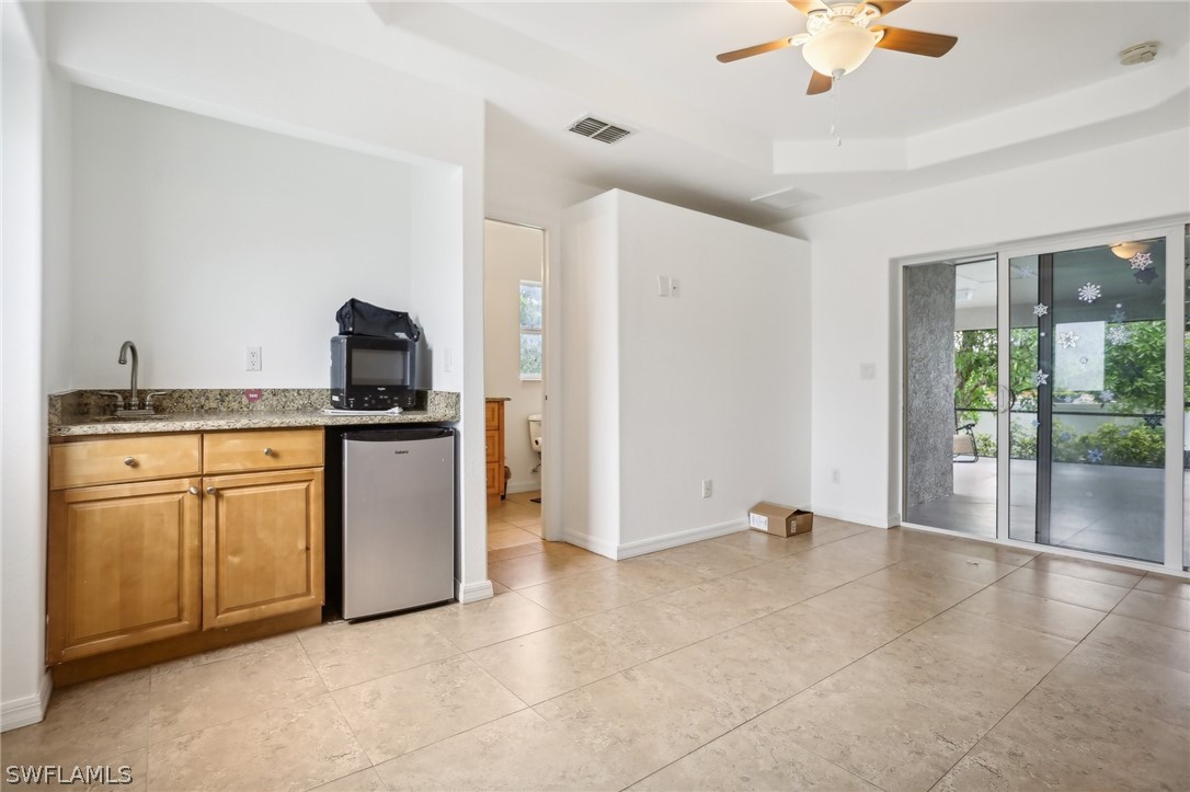 18364 Camellia Road Fort Myers, FL 33967 - Photo 33 of 48 a kitchen with granite countertop a stove a sink and a refrigerator with white cabinets