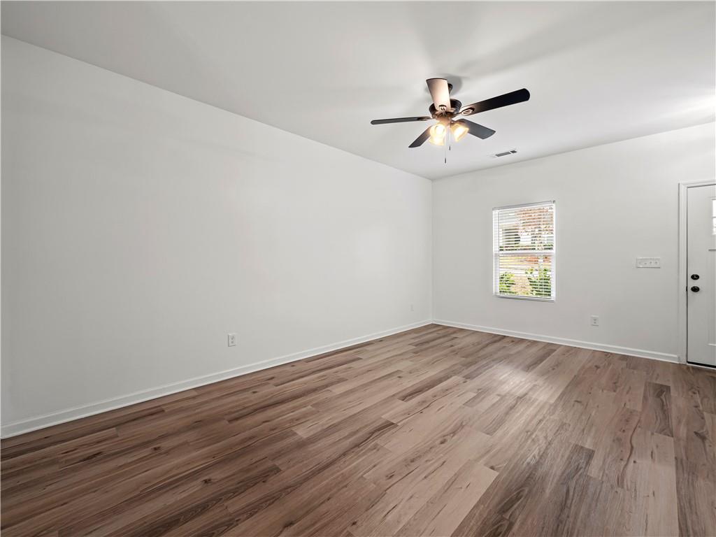 4334 Box Elder Path Gainesville, GA 30504 - Photo 11 of 39 an empty room with wooden floor ceiling fan and windows