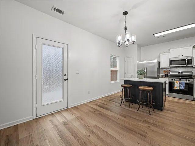 a view of kitchen and refrigerator with wooden floor