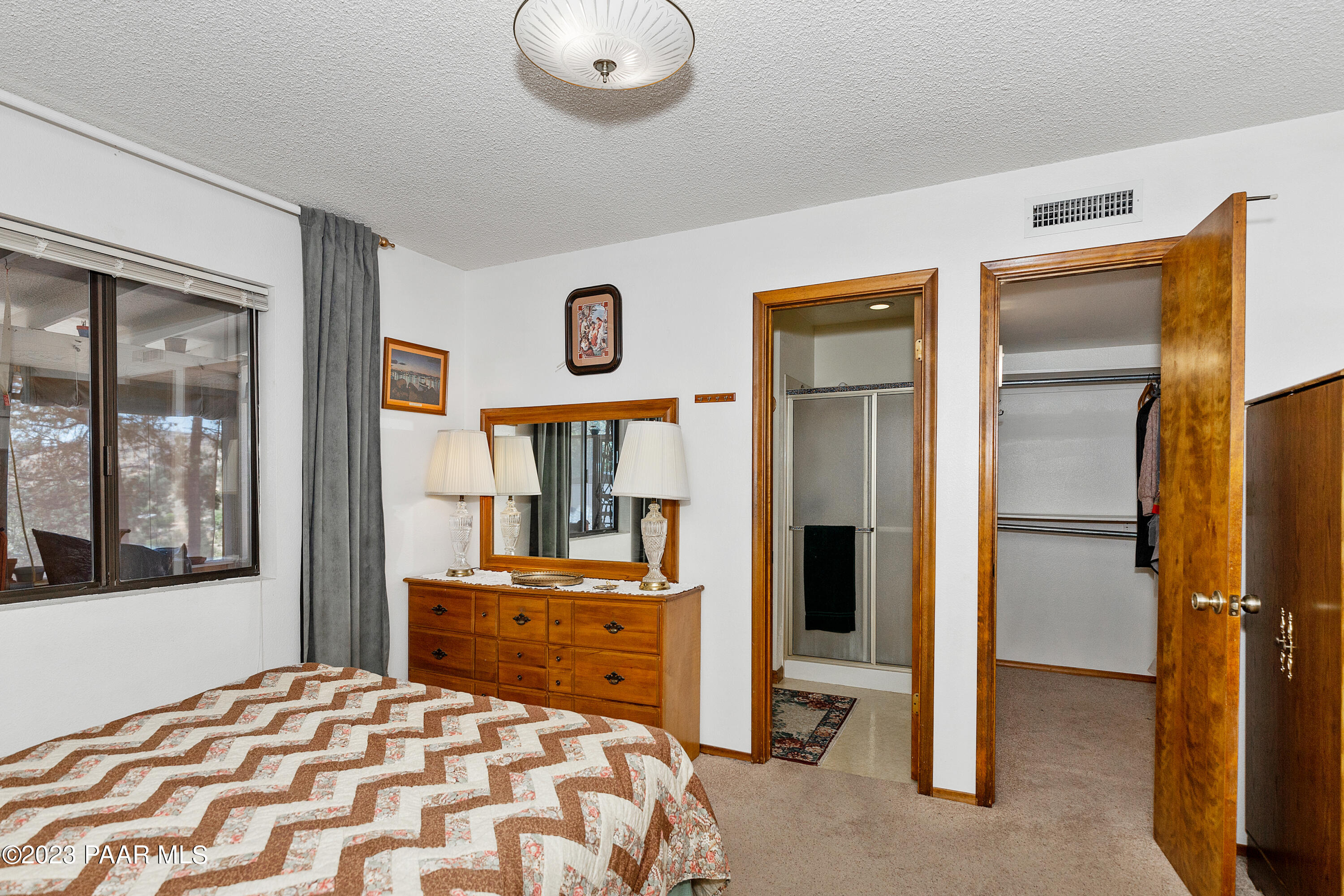 2680 Ridge Road Prescott, AZ 86301 - Photo 12 of 25 a bedroom with a bed and a large mirror next to a window
