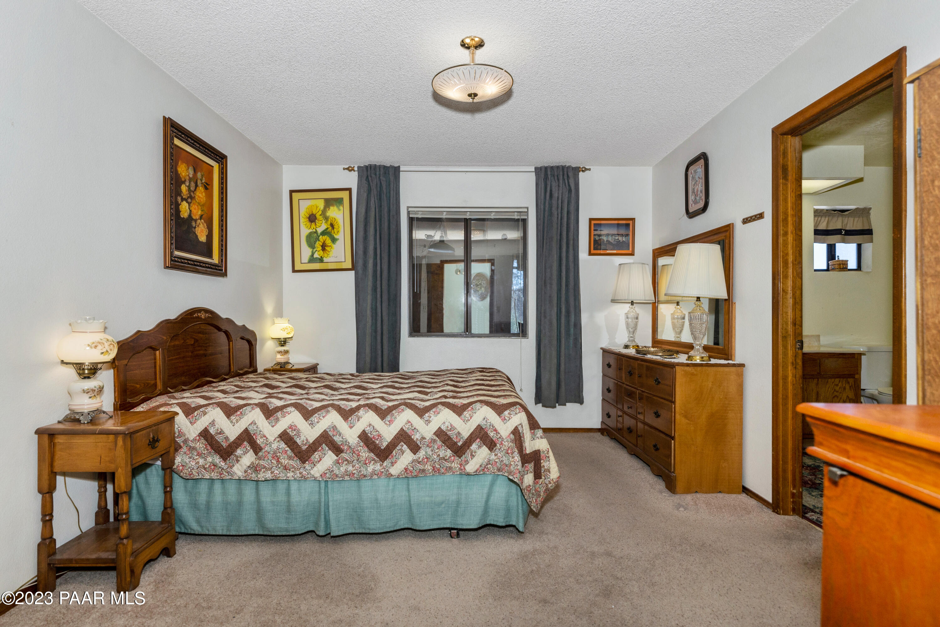 2680 Ridge Road Prescott, AZ 86301 - Photo 9 of 25 a bedroom with a bed and dresser with mirror