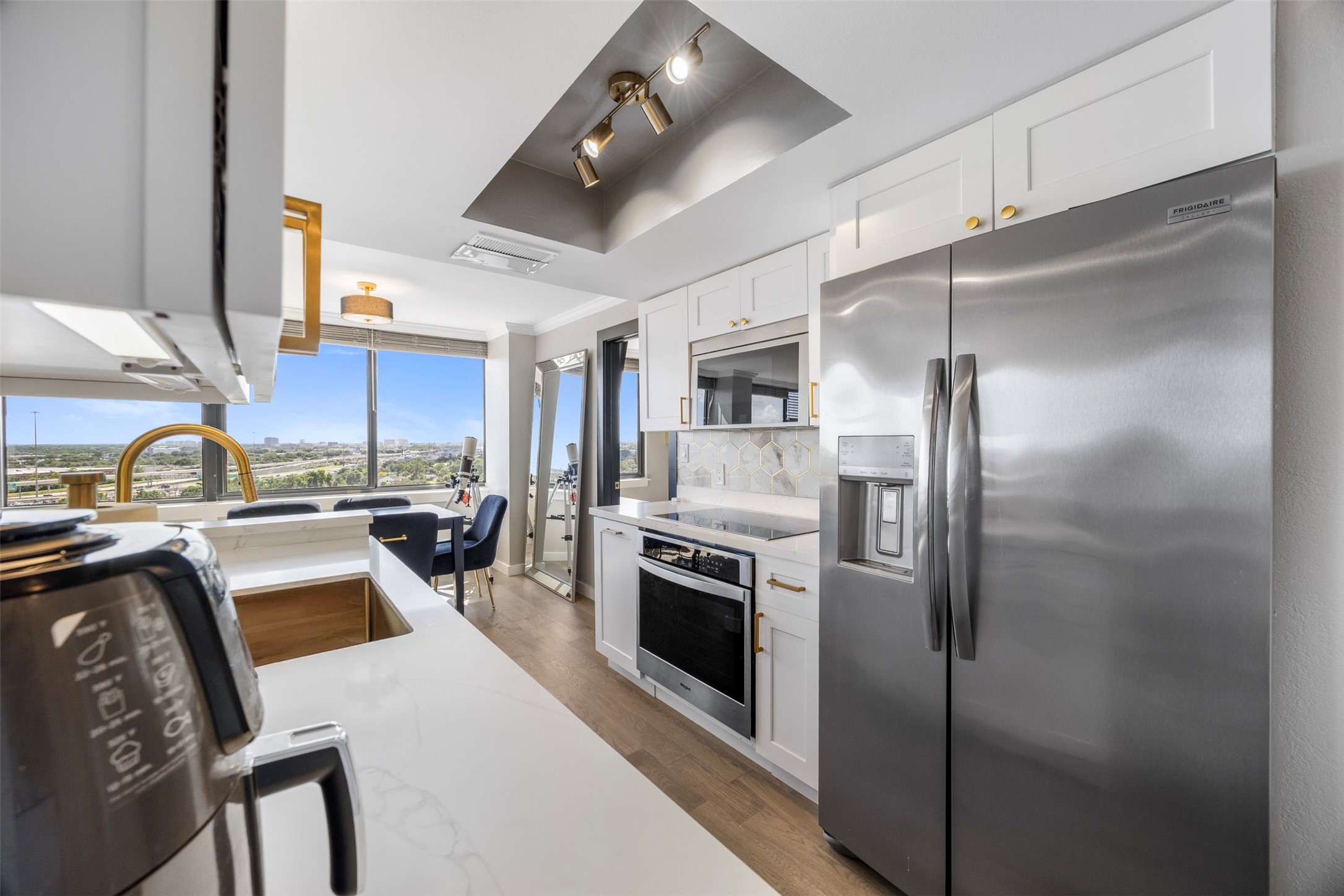 3525 Sage Road, Unit 1403 Houston, TX 77056 - Photo 12 of 47 a kitchen with a refrigerator a sink and a stove top oven with wooden floor