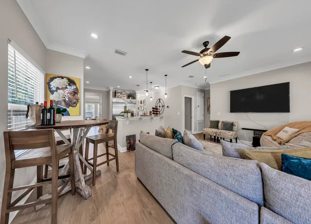 a living room with furniture floor to ceiling window and a flat screen tv