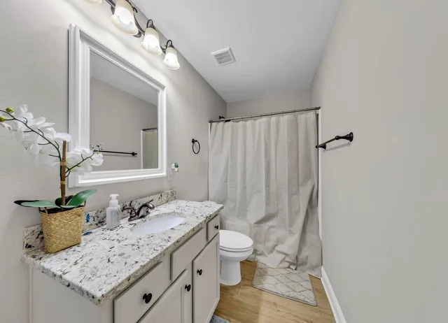 an empty room with windows and ceiling fan