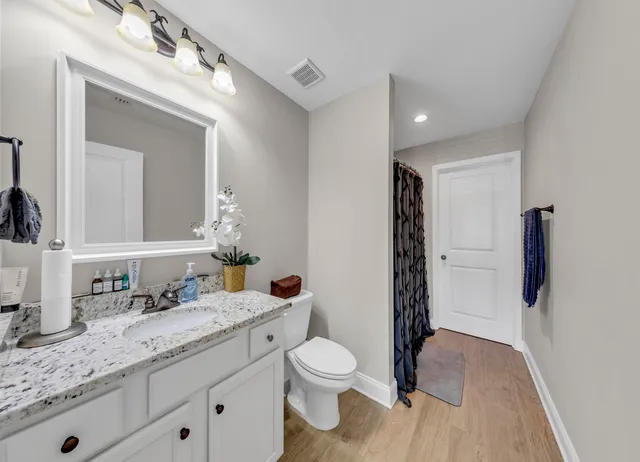 a spacious bedroom with a bed a couch and a chandelier