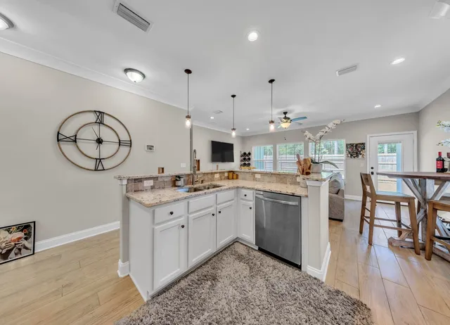 a kitchen with stainless steel appliances granite countertop a sink stove and wooden floor