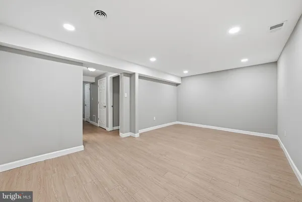 an empty room with wooden floor and natural light