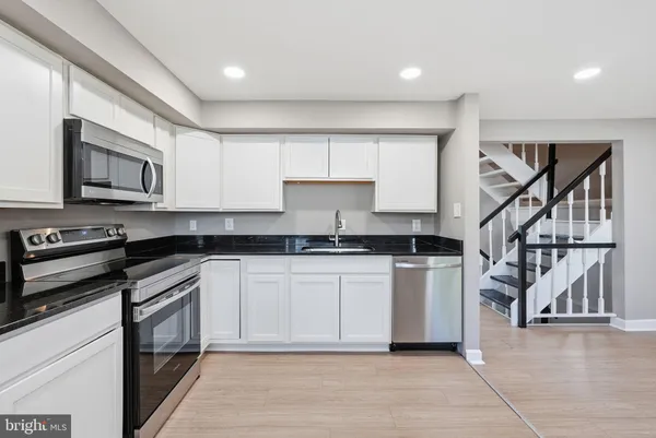 a kitchen with stainless steel appliances granite countertop a stove a sink and a microwave