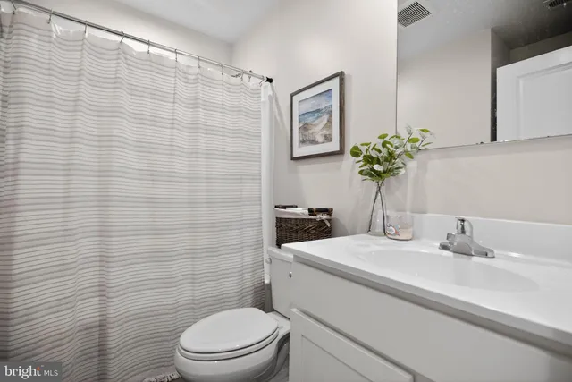 a bathroom with a sink a toilet and mirror