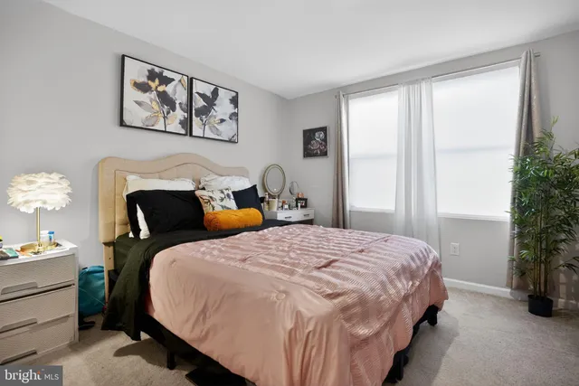 a bedroom with a bed and a potted plant