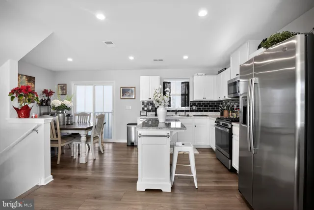 a kitchen with a dining table chairs appliances and cabinets