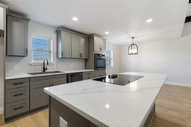 a kitchen with a sink window and cabinets