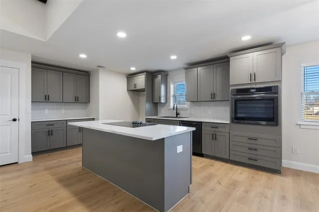 a kitchen with a sink microwave and cabinets