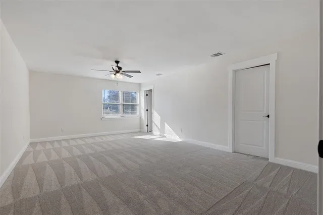 a view of a livingroom with a ceiling fan and window
