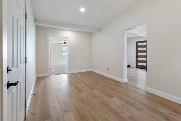 an empty room with ceiling fan and window