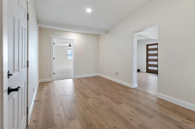 an empty room with ceiling fan and window