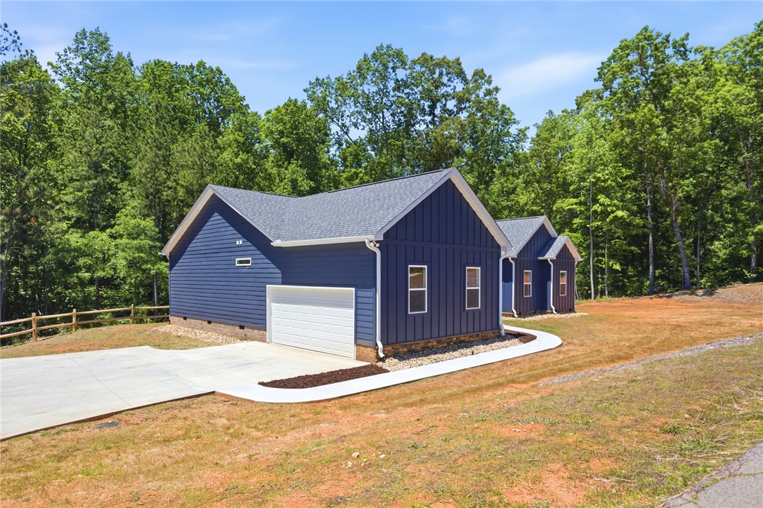 912 Watercrest Road West Union, SC 29696 - Photo 2 of 49 This modern home features striking blue siding, a welcoming driveway, and lush surrounding trees.