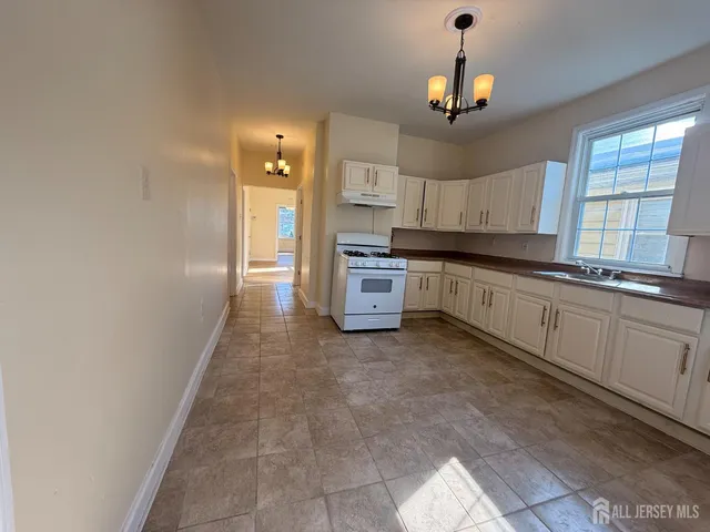 a kitchen with stainless steel appliances granite countertop a refrigerator a stove top oven a sink and dishwasher