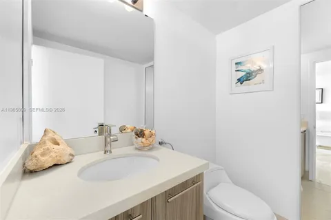 a bathroom with a granite countertop sink a toilet and shower