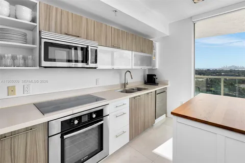a kitchen with stainless steel appliances a sink a stove and cabinets