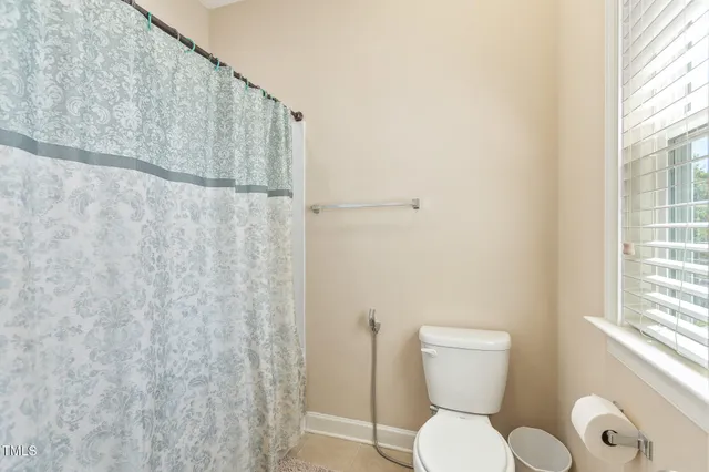 a bathroom with a toilet and a shower curtain