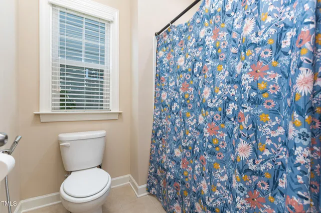 a white toilet sitting next to a shower curtain