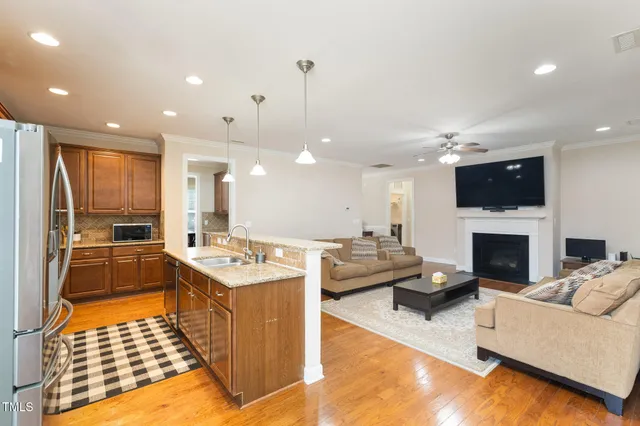 a large living room with stainless steel appliances kitchen island granite countertop a stove and a view of living room