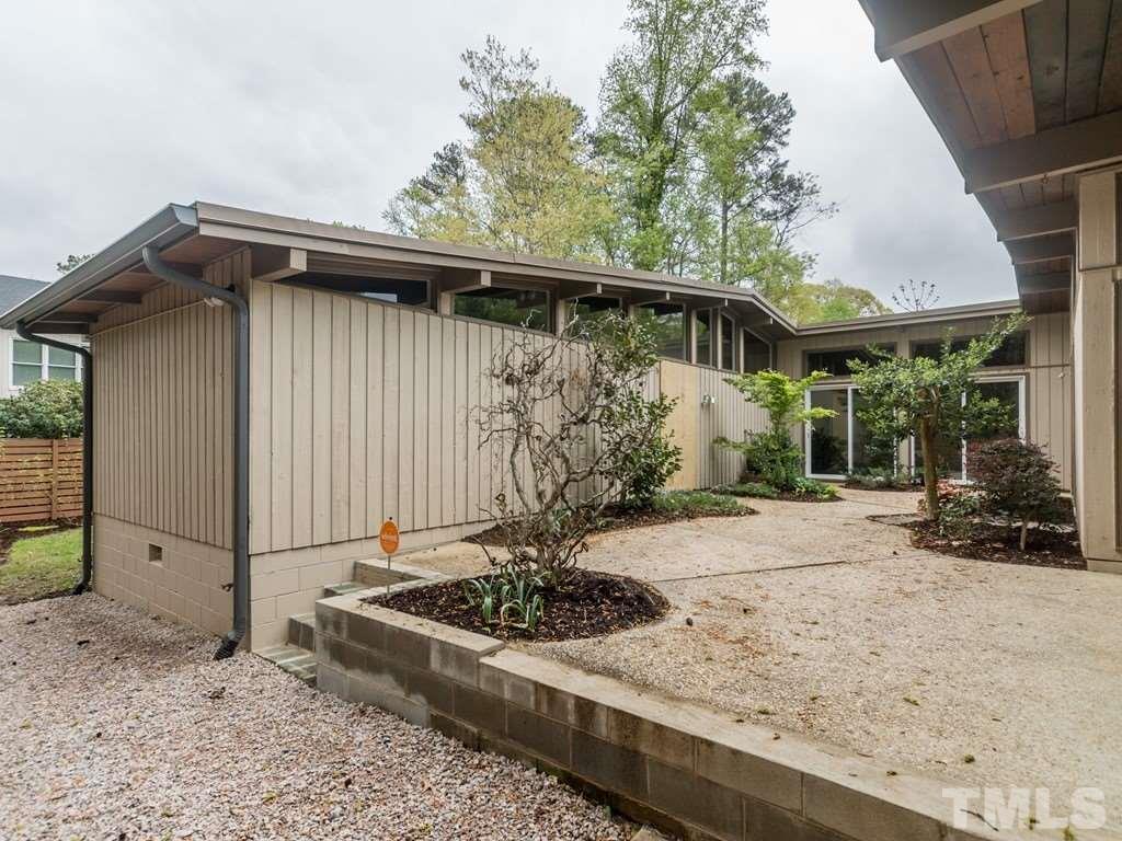 3612 Anclote Place Raleigh, NC 27607 - Photo 22 of 25 a view of a wooden house with a large window and potted plants
