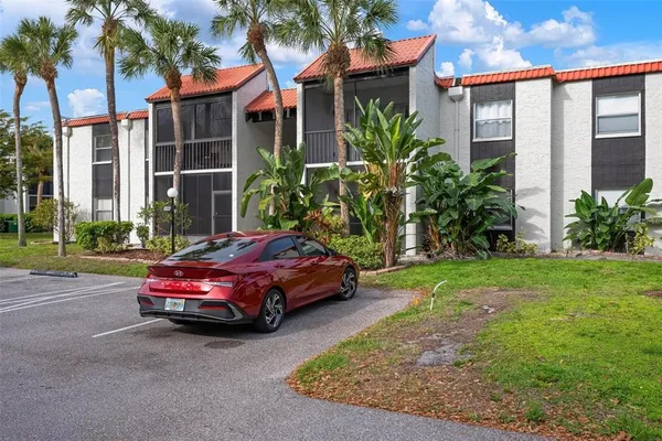 a car parked in front of a brick house with a yard
