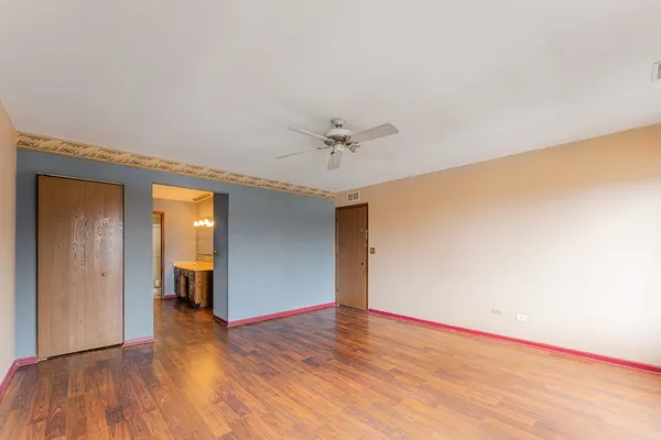 a view of a room with wooden floor and a ceiling fan