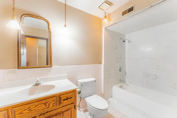a bathroom with a sink a toilet a mirror and bathtub