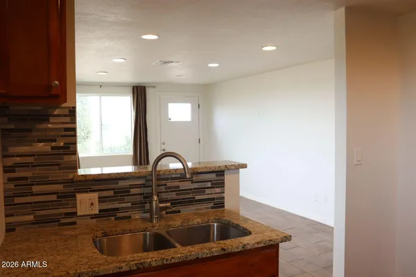 a kitchen with stainless steel appliances granite countertop a sink a stove and a refrigerator