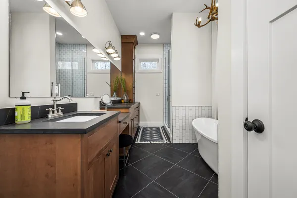 a spacious bathroom with a granite countertop sink a mirror and shower view